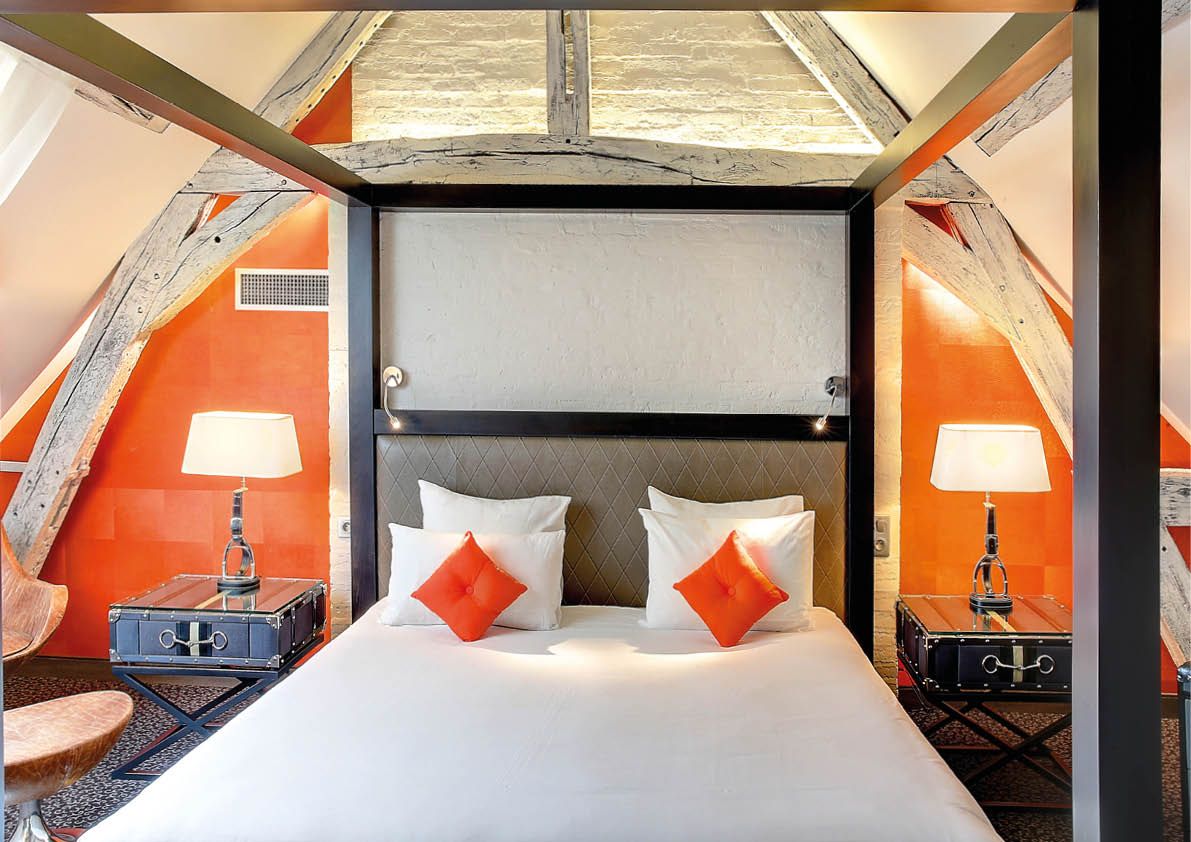 Chambre poutre bois grand lit blanc oreiller rouge